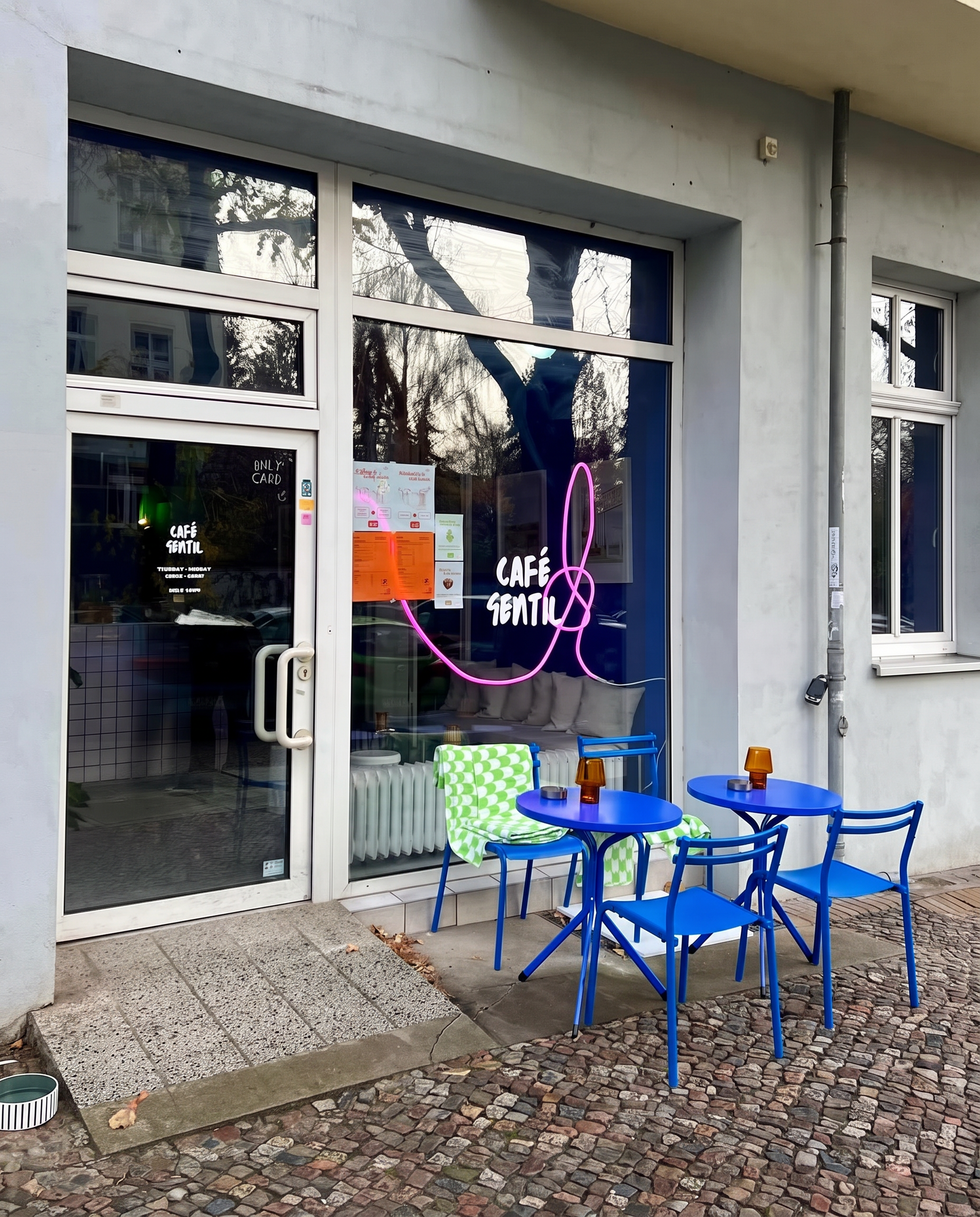 Exterior of Café Gentil with blue bistro furniture
